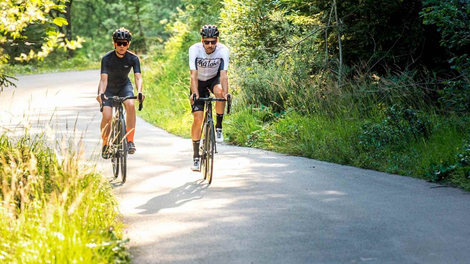 Die Bikeprofis fahren im Wald auf den Berg. 