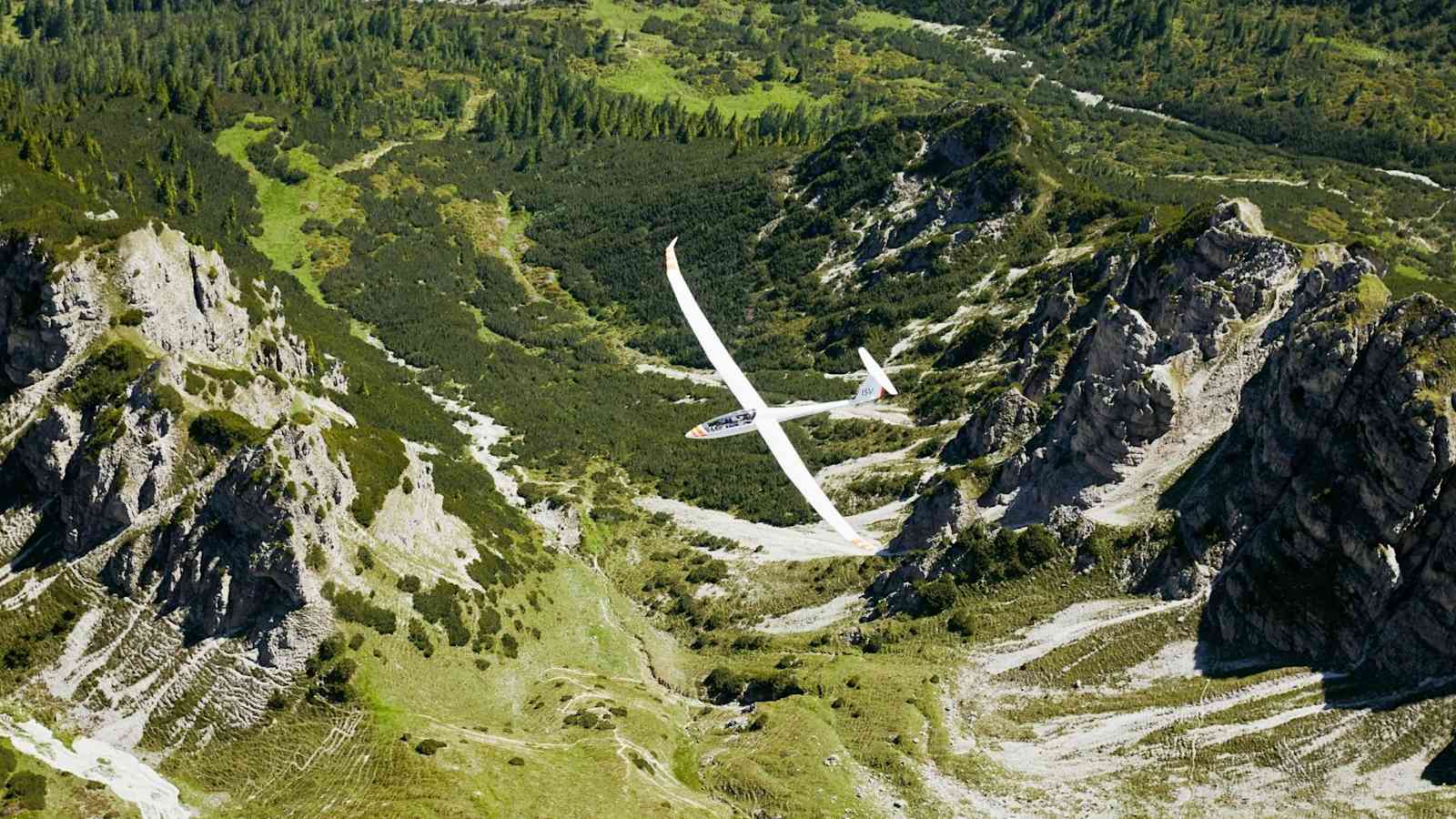 Das Flugzeug ist kaum zu erkennen in den Bergen.