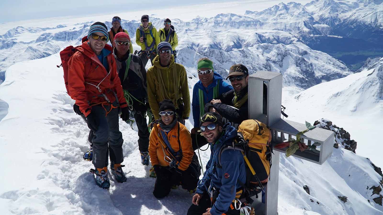 Bergführer mit Gruppe am Gipfel