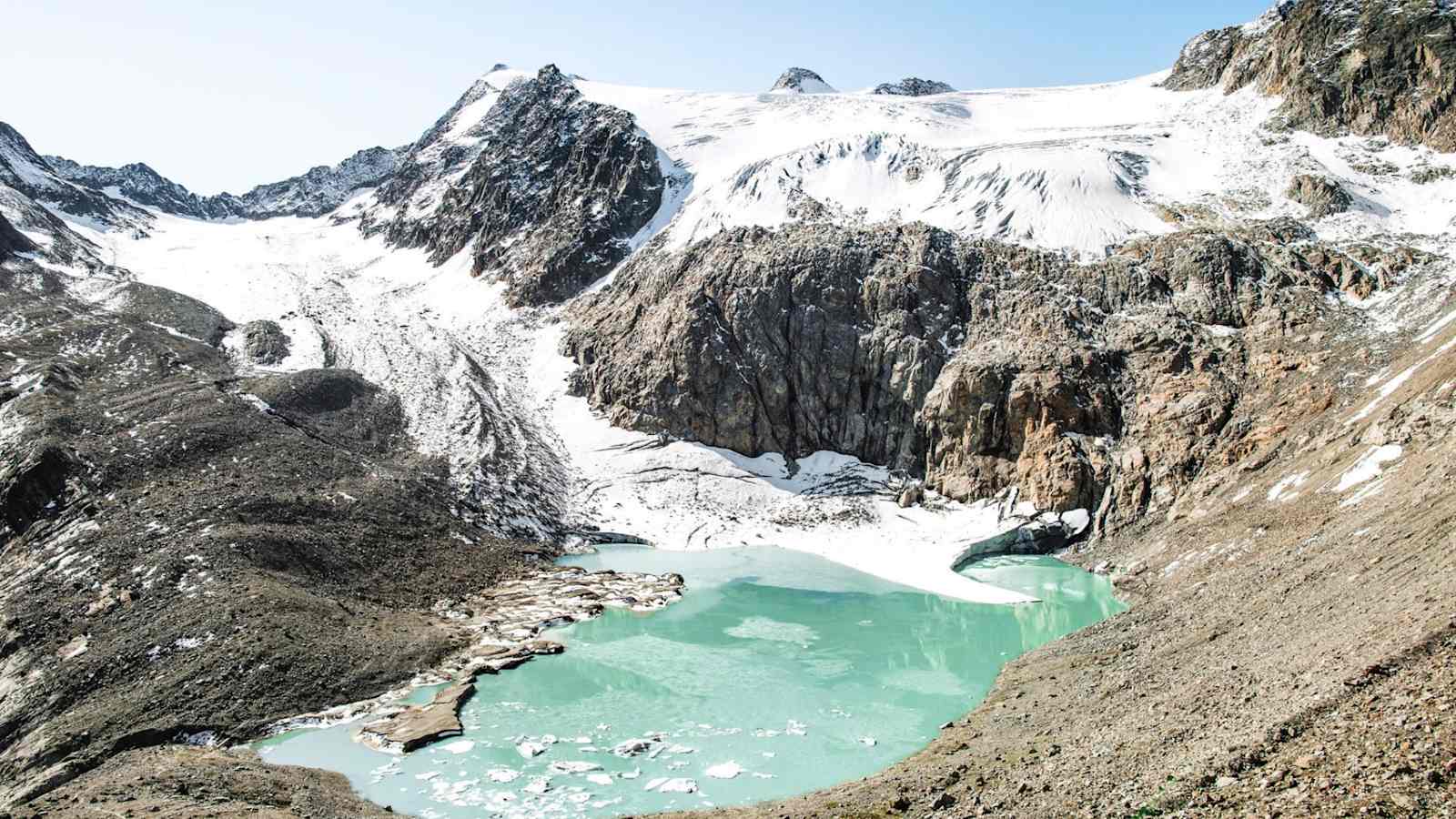 Ein Bergsee umringt von Gesteinen.