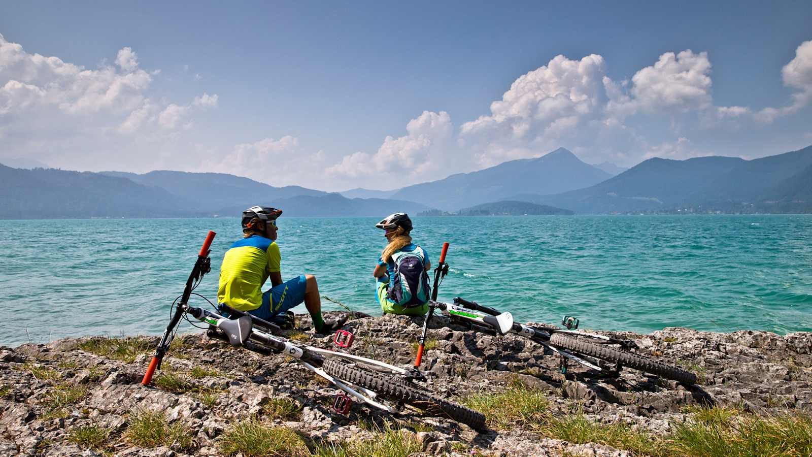 Zwei Radfahrer machen eine kurze Rast am Ufer.