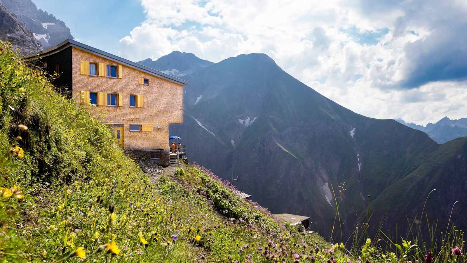 Die Hütte schmiegt sich an den Grashang und bettet sich in die Landschaft ein