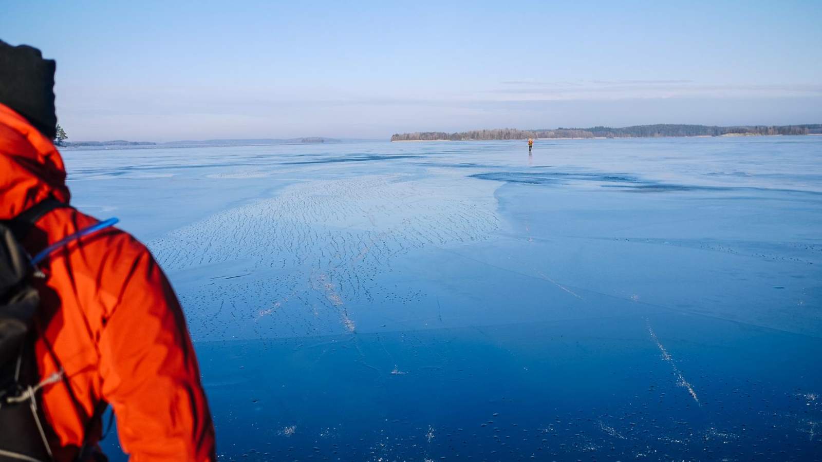 Blauer Himmel und blaues Eis in Schweden mit Anschnitt eines Nordic Skaters 