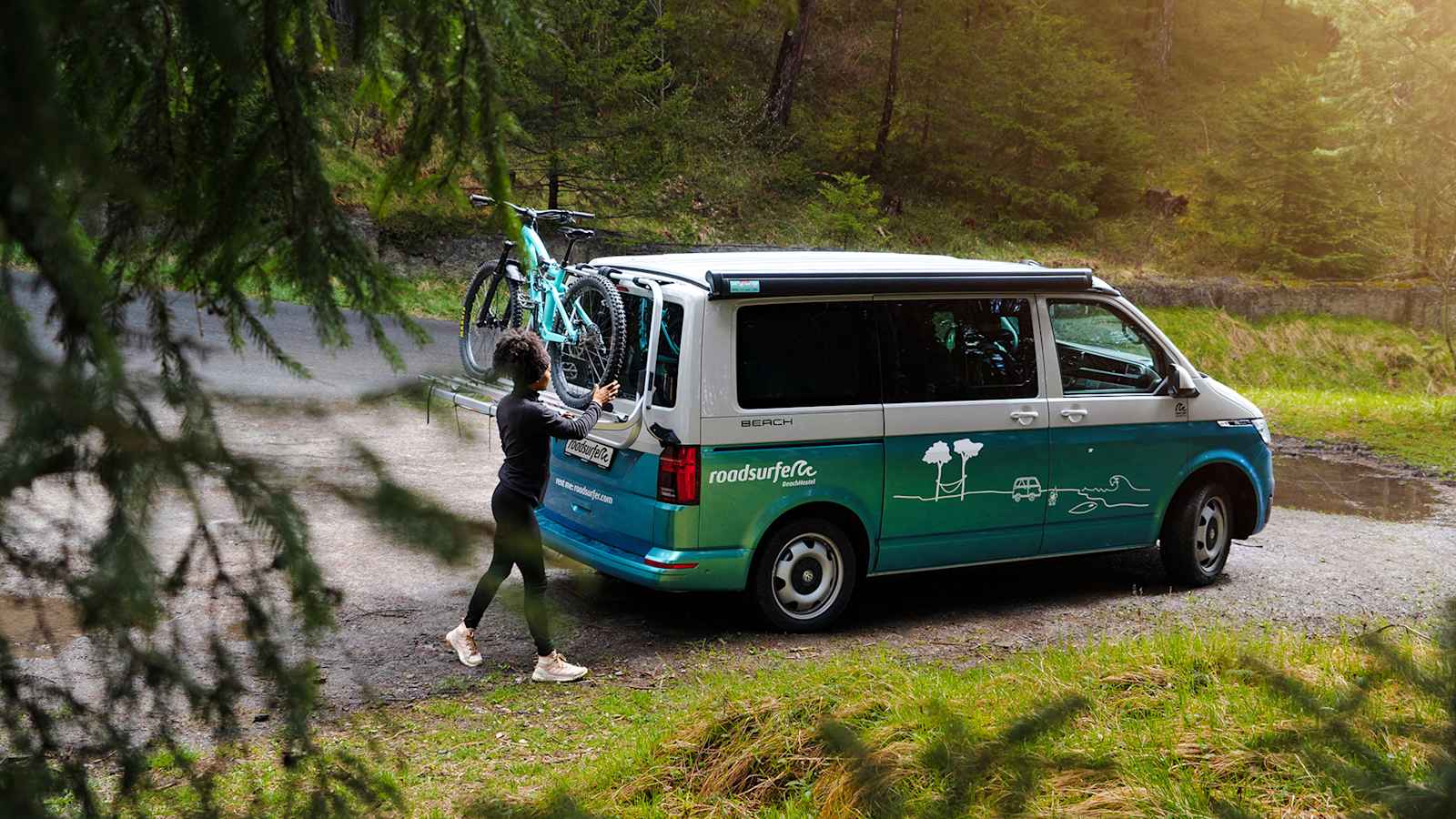 Mit dem Bike am Camper und dem Wald vor der Tür.