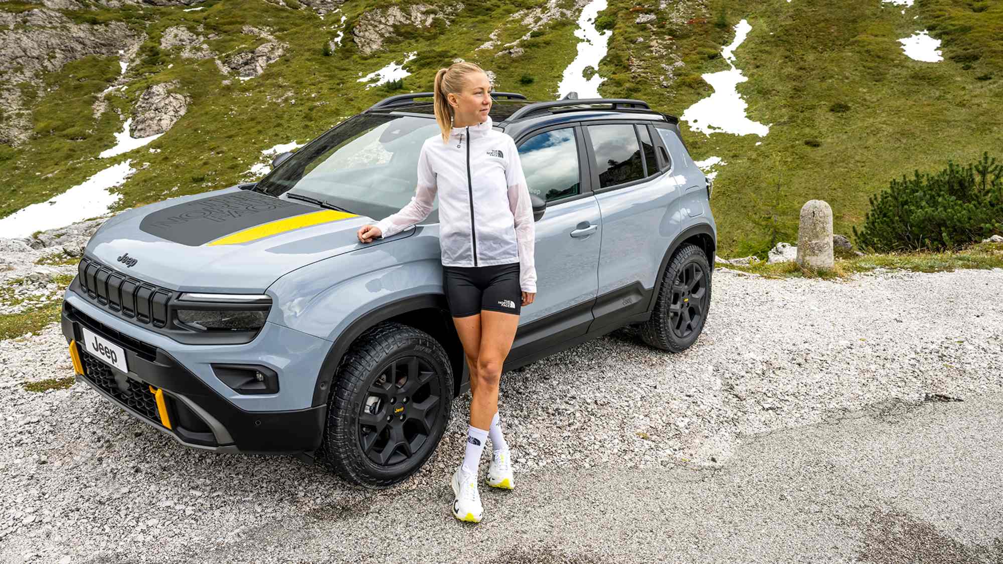 Eine Frau steht vor dem neuen Avenger 4xe the North Face Edition von Jeep®.
