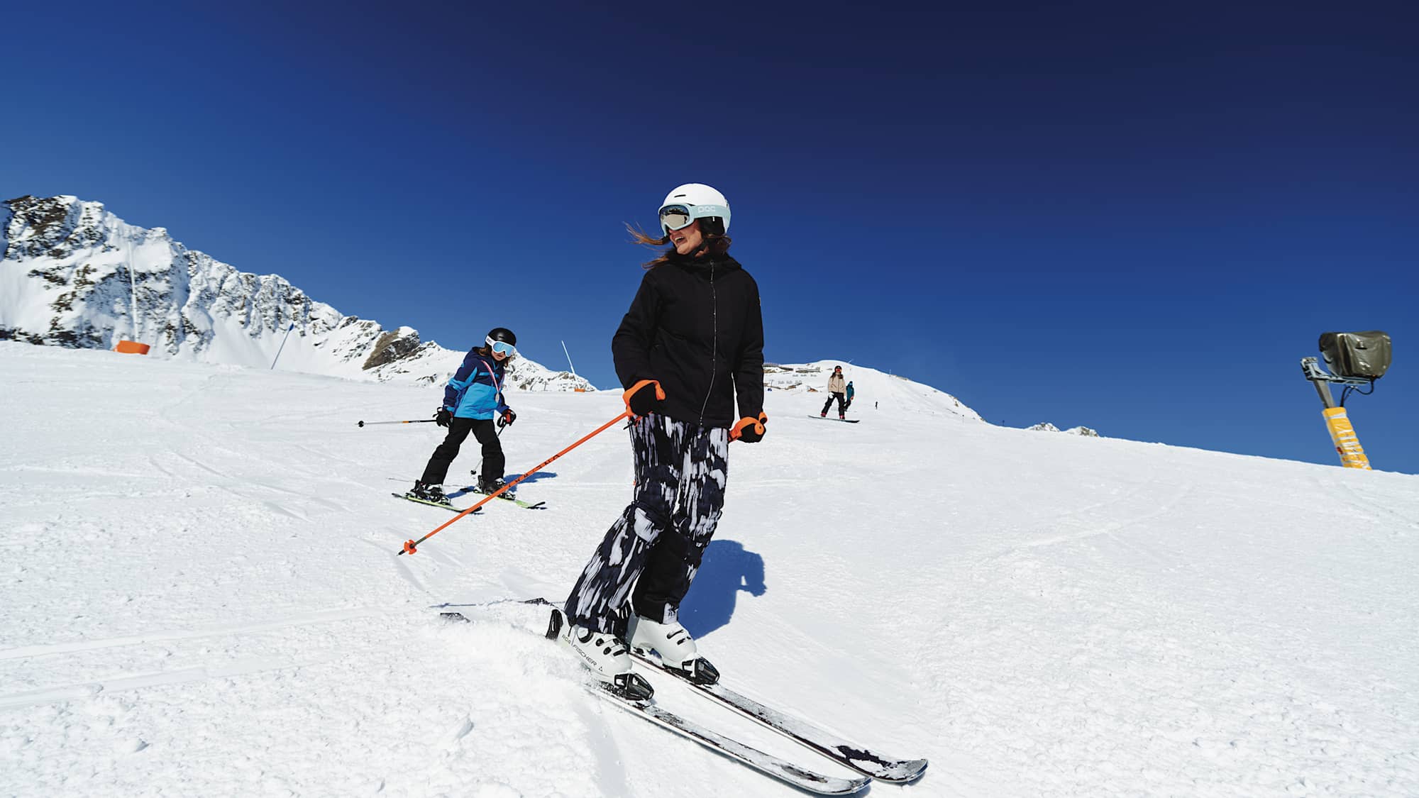 Eine Mutter fährt mit ihrem Kind einen Hang im Skigebiet Kappl hinunter.