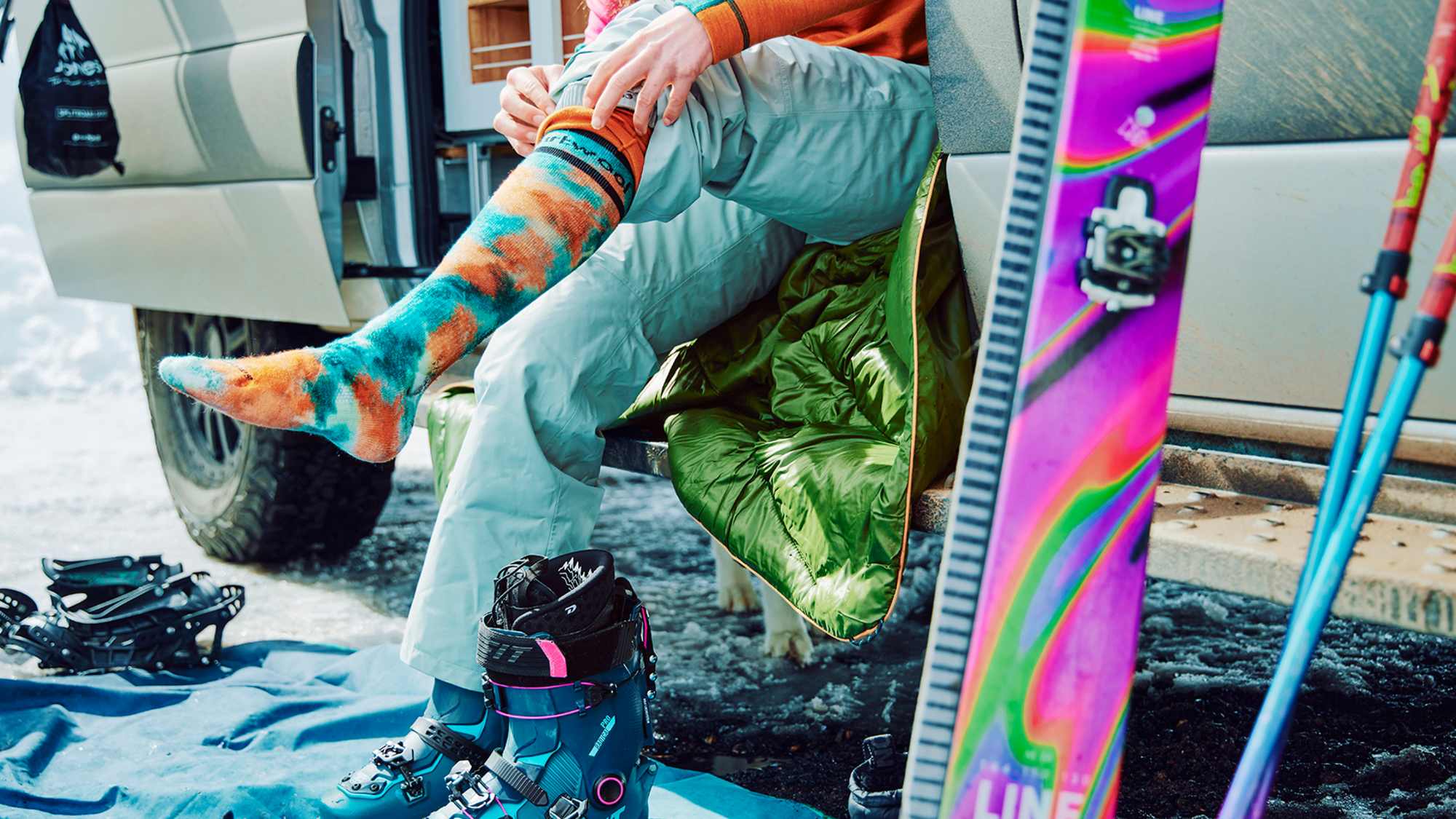 Frau zieht sich zum Skifahren Socken von Smartwool an.