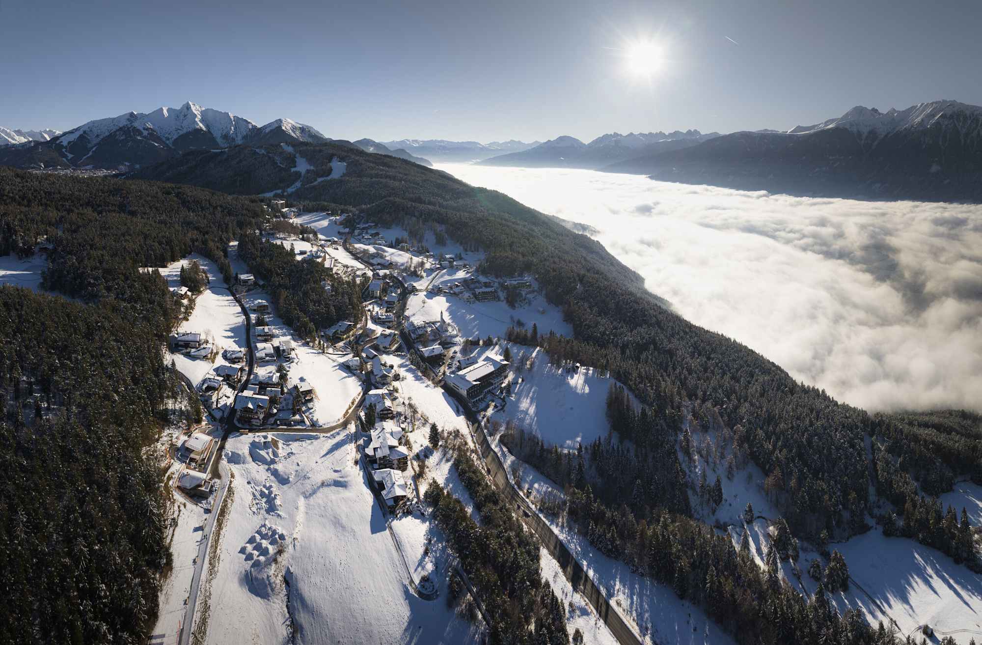 Mösern bei Mittagslicht mit Nebel über dem Inntal