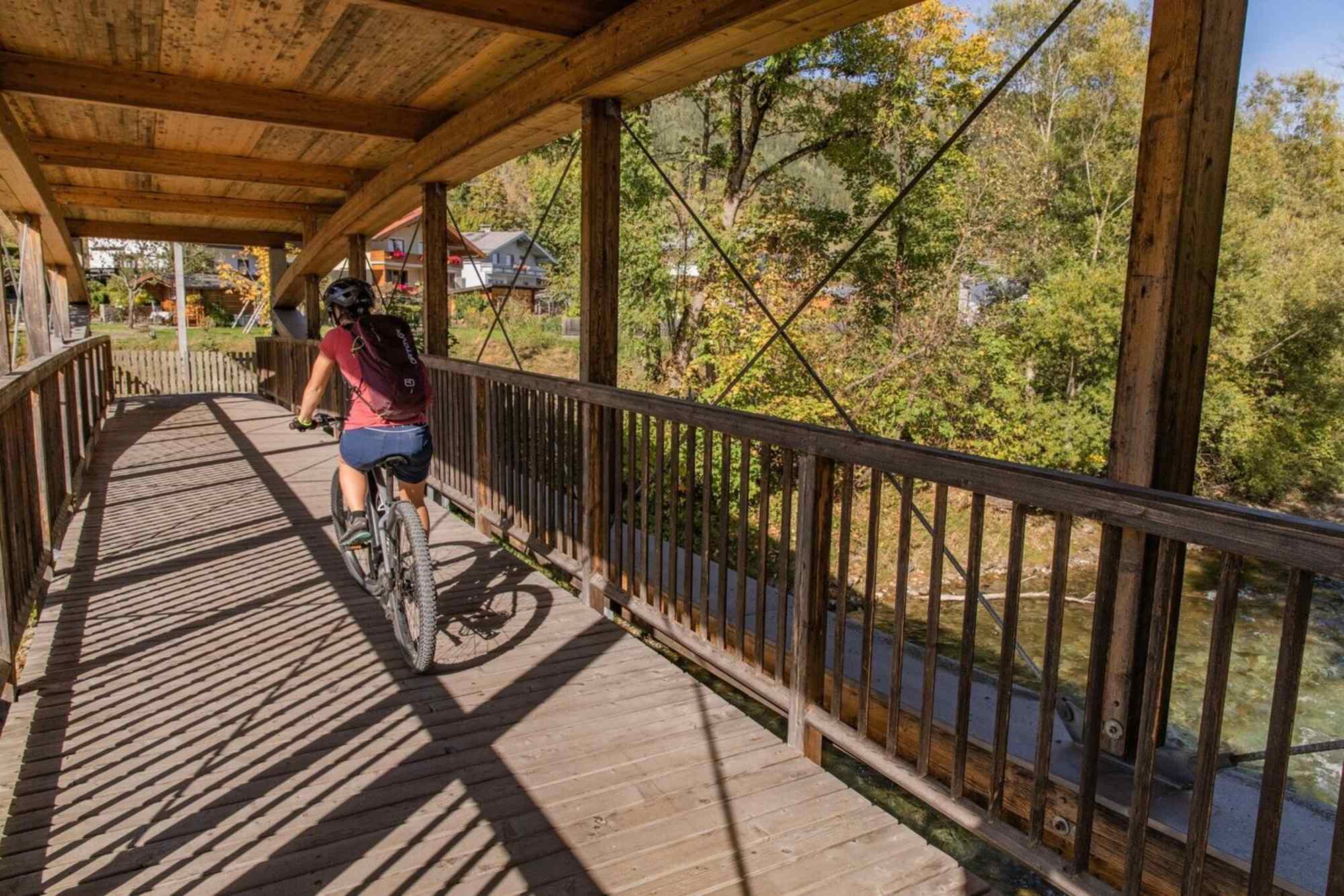 Über eine überdachte Holzbrücke