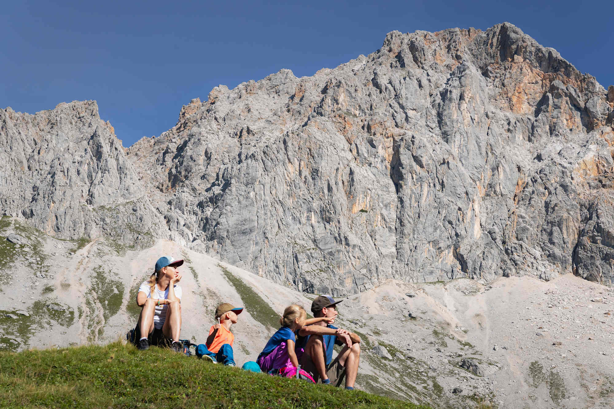 Familienwanderung im Gaistal: Familie sitzt auf Wiese vor Wetterstein