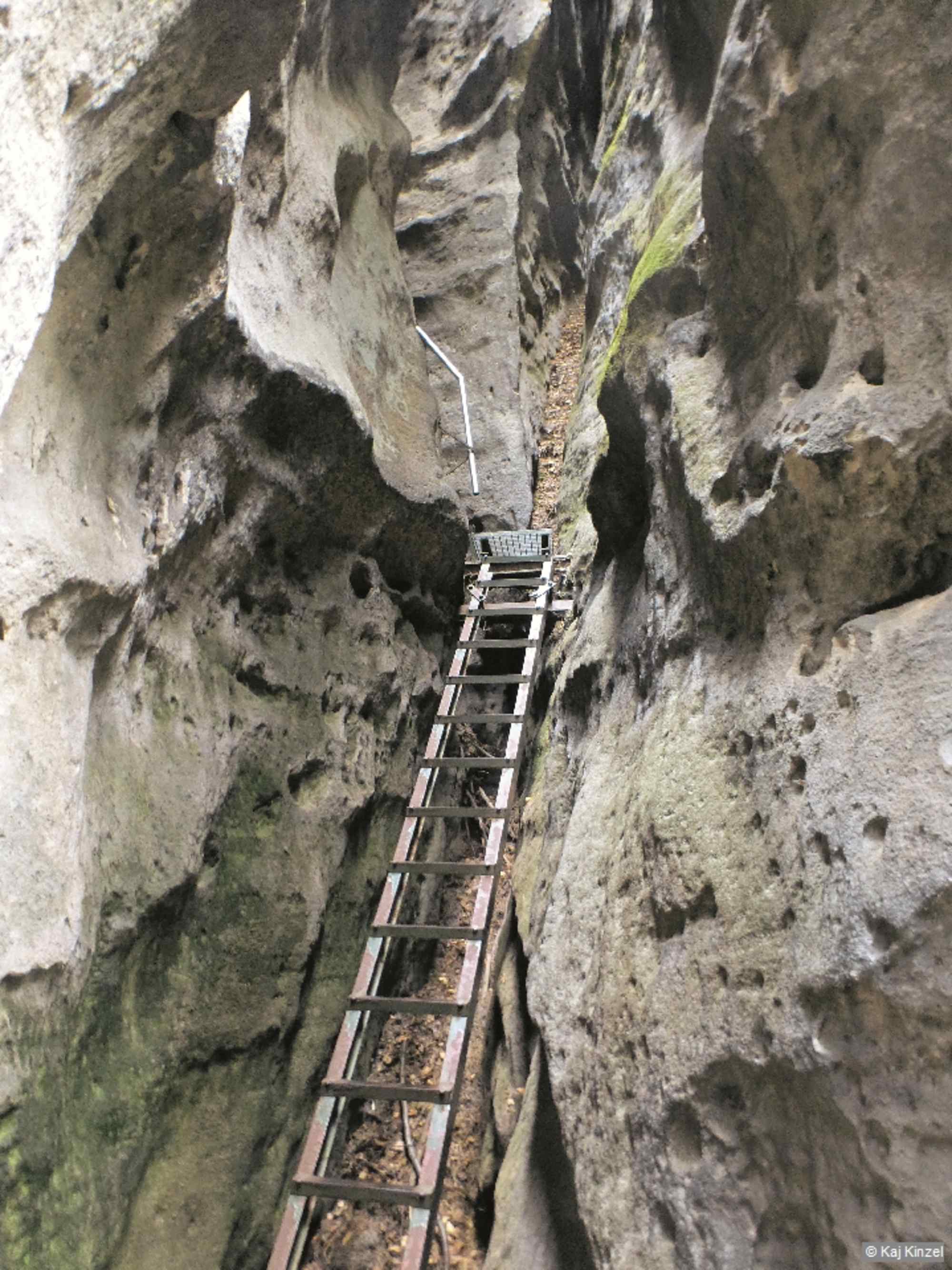 Die steile Steiganlage führt durch eine schmale Schlucht hinauf.