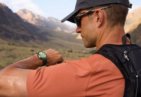 Outdoor-Sportler blickt auf seine HUAWEI WATCH GT 6 – präzises GPS-Tracking beim Laufen in den Bergen.