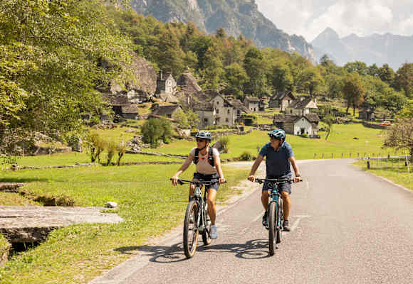 Zwei Fahrradfahrer fahren auf den gut ausgebauten Straßen im Kanton Tessin.