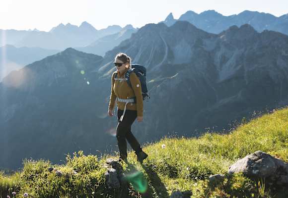 Eine Wanderin vor einer Bergkulisse.