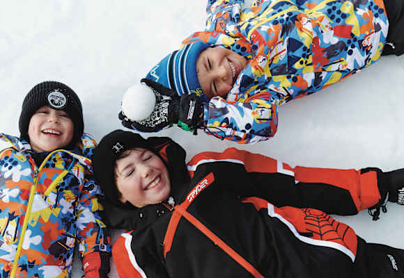 Drei Kinder liegen im Schnee in See.