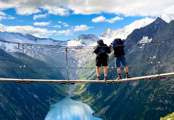 Hängebrücke über dem Schlegeisspeicher in den Zillertaler Alpen. Eine Aussicht, die Lust auf den ersten Dreitausender macht.