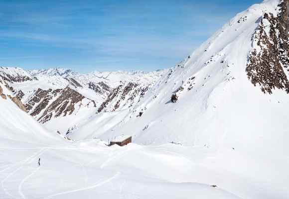 Die moderne Hütte schmiegt sich in die alpine Landschaft.