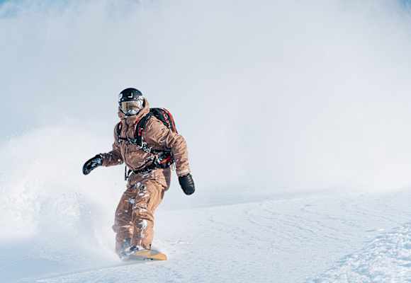 Camille Armand auf seinem Snowboard beim Carven durch den Pulverschnee.