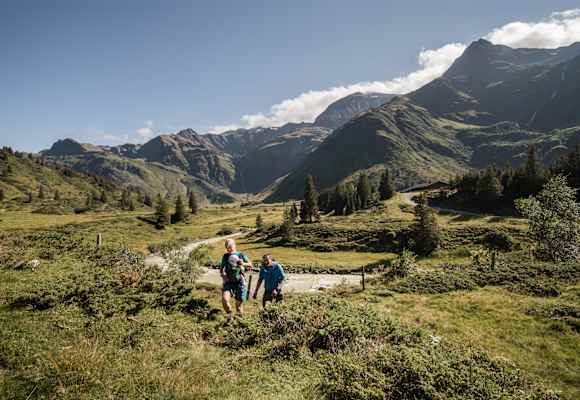 Zwei Wanderer mit Baby stapfen durch das Gasteinertal.