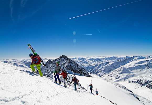 Die Alpinisten stapfen den Berg hinauf.