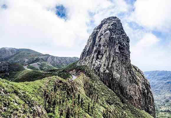 Ein Felsturm eingebettet in satten Grün