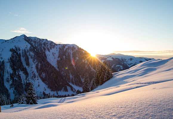 Die Abendsonne verschwindet hinter den schneebedeckten Gipfeln.