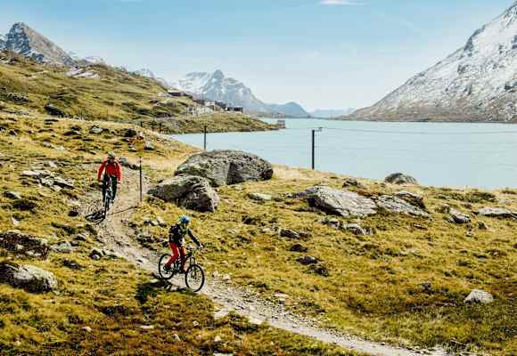 Mountainbiker fahren neben einem See.