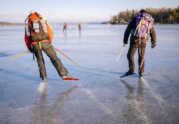 Zwei Nordic Skater mit Rucksäcken auf einem gefrorenen See nahe Uppsala 