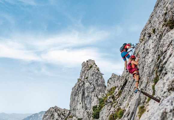 Kletterer am Pidinger Klettersteig und im Hintergrund das Alpenvorland