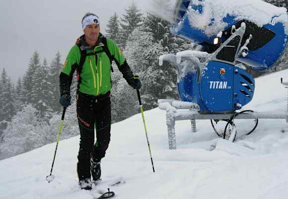 Skitourengeher im Skigebiet auf präparierter Piste