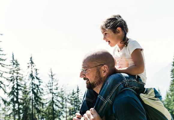 Das kleine Mädchen Lina sitzt auf den Schultern ihres Papas.