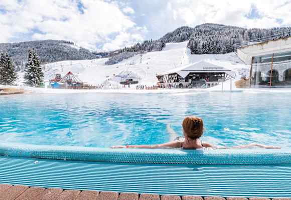 Vom Außenpool des Römerbades kann man den Skifahrern auf der Piste zusehen.