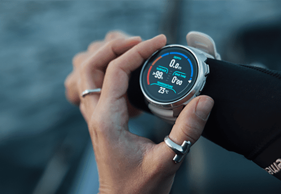 Eine Taucherin trägt die SUUNTO Sportuhr auf ihrem Handgelenk im Boot.