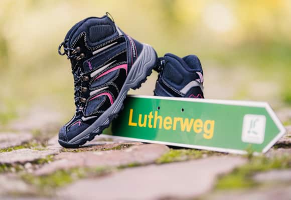 Lutherweg Sachsen Schild und Wanderschuhe