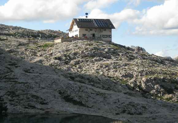 Die Pisciadù-Hütte steht in der nördlichen Sellagruppe und südlich des Grödner Jochs am Ufer des türkisfarbenen Pisciadùsees in Südtirol.