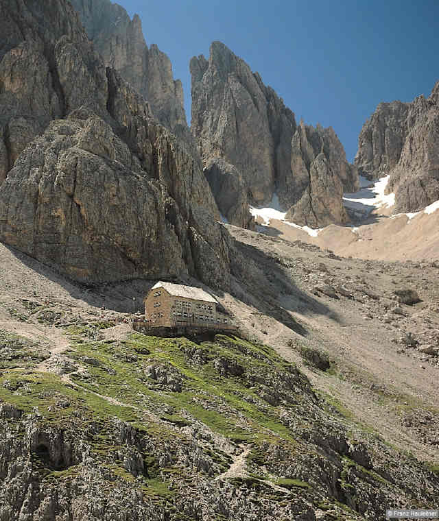 Die großartig gelegene Langkofelhütte mit dem markanten Zahnkofel darüber.
