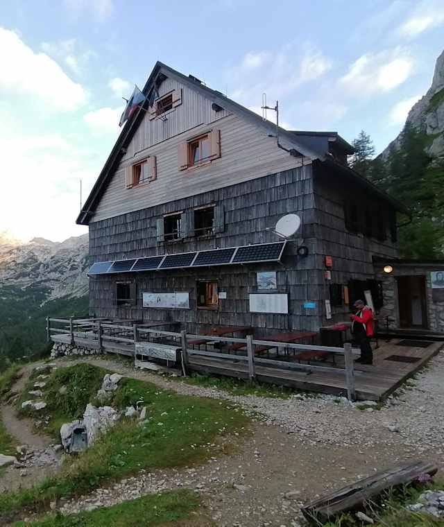 Vodnikov dom na Velem polju – dahinter das Triglav-Massiv und Mišelj vrh (li)