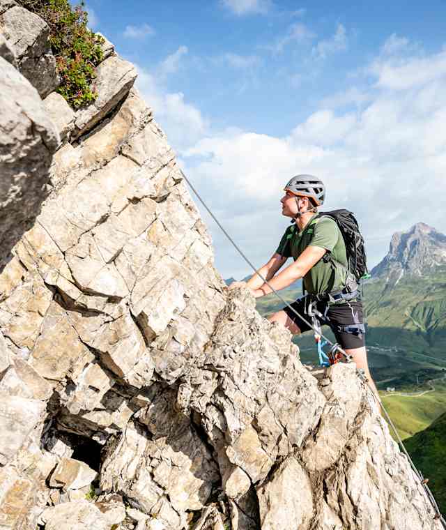 Zwischen Lechquellengebirge und Allgäuer Alpen: Über dem Wiesenteppich von Warth erheben sich die Kalkfelsen des Karhorns, an dessen Nordostgrat wir hinaufklettern. Im Hintergrund ist der Widderstein zu sehen.