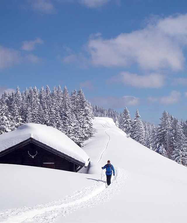 Verschneite Holzhütte entlang des Aufstiegs